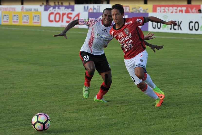 Pesepak bola Bali United, Irfan Bachdim (kanan) berebut bola dengan pesepak bola Persipura Yustinus Pae dalam Pertandingan Liga 1 di Stadion I Wayan Dipta, Gianyar, Bali, Minggu (23/4). 