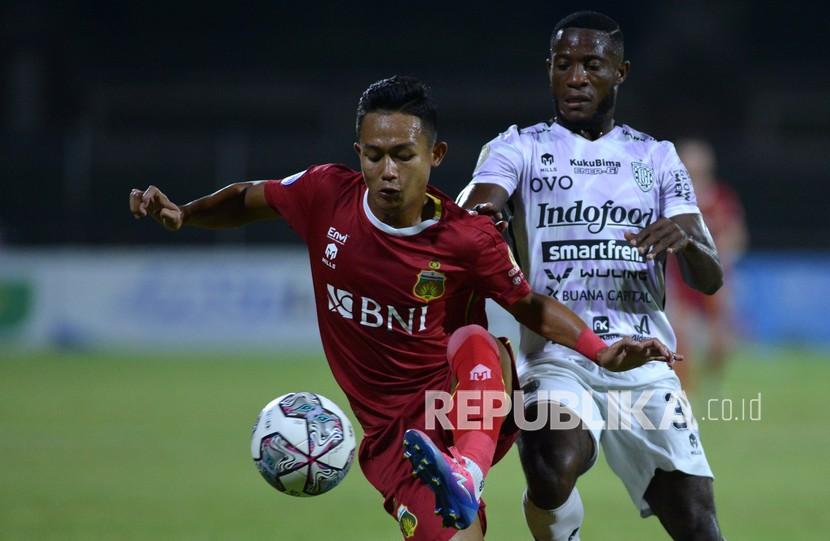 Pesepak bola Bali United Privat Mbarga (kanan) berebut bola dengan pesepak bola Bhayangkara FC Sani Rizki Fauzi (kiri) saat pertandingan Liga 1 di Stadion I Gusti Ngurah Rai, Denpasar, Bali, Sabtu (12/2/2022). Bali United berhasil mengalahkan Bhayangkara FC dengan skor 3-0.