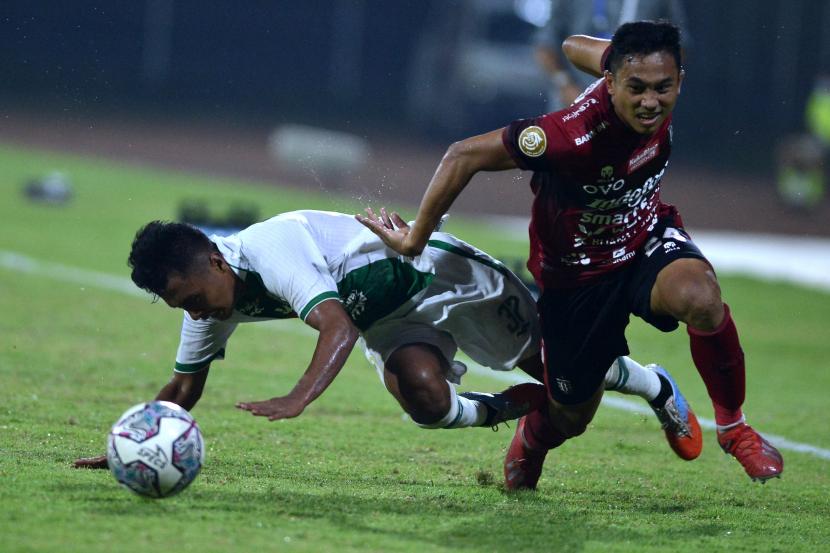 Pesepak bola Bali United Ricky Fajrin (kanan) berebut bola dengan pesepak bola PSS Sleman Bagas Umar (kiri) saat pertandingan Liga 1 di Stadion I Gusti Ngurah Rai, Denpasar, Bali, Rabu (16/2/2022).