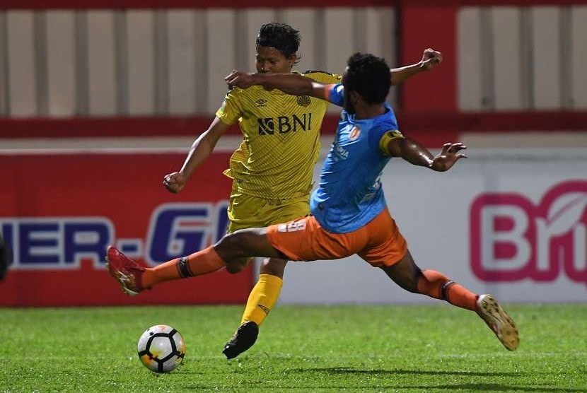 Pesepak bola Bhayangkara FC Adam Alis Setyono (kiri) berebut bola dengan pesepak bola Perseru Arthur Barrios Bonai (kanan) dalam laga lanjutan Liga 1 di Stadion PTIK, Jakarta, Rabu (12/9). Bhayangkara berhasil menang dengan skor 1-0. 