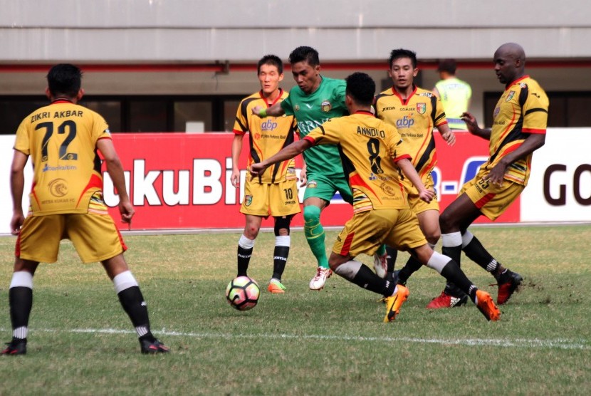 Pesepak bola Bhayangkara FC Alsan Putra Masat Sanda (tengah) menggiring bola melewati hadangan pesepak bola Mitra Kukar pada pertandingan Liga 1, di Stadion Patriot Candrabhaga, Bekasi, Jawa Barat, Jumat (21/7).