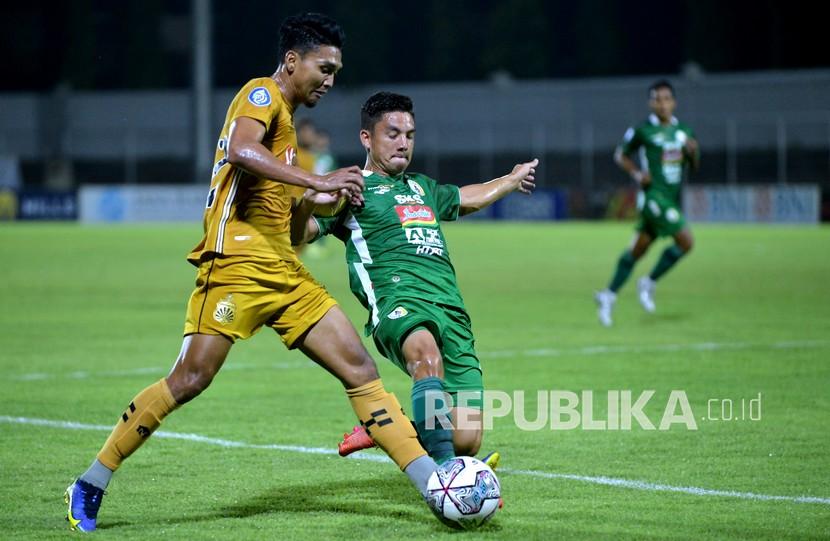 Pesepak bola Bhayangkara FC Dendy Sulistyawan (kiri) berebut bola dengan pesepak bola PSS Sleman Kim Kurniawan (kanan) saat pertandingan Liga 1 di Stadion Kompyang Sujana, Denpasar, Bali, Senin (7/3/2022). 