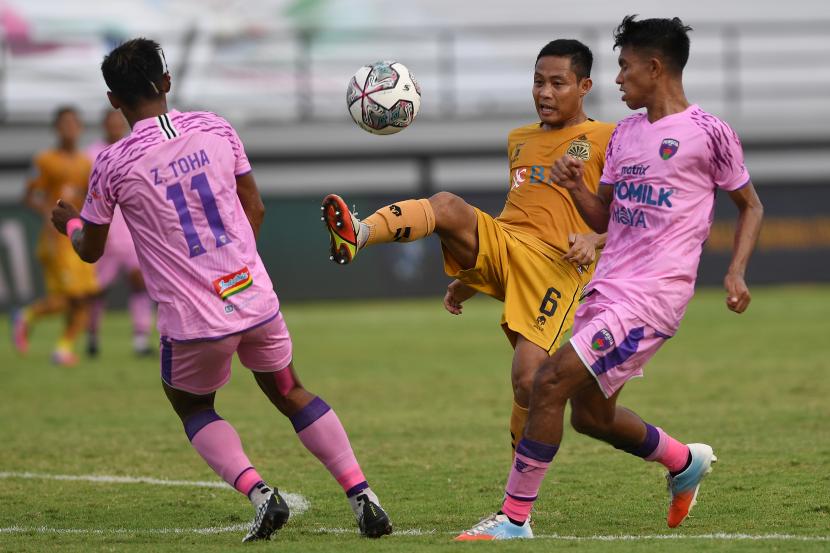 Pesepak bola Bhayangkara FC Evan Dimas (tengah) berupaya melewati pemain Persita Tangerang Kasim Botan (kanan) dan Muhammad Toha (kiri) dalam pertandingan sepak bola Liga 1 di Stadion I Wayan Dipta, Gianyar, Bali, Selasa (1/3/2022). Pertandingan berakhir imbang dengan skor 2-2. 