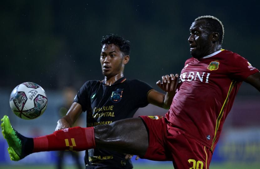 Pesepak bola Bhayangkara FC Herman Dzumafo (kanan) berebut bola dengan pesepak bola PSIS Semarang Resky Fandi (kiri) saat pertandingan Liga 1 di Stadion I Gusti Ngurah Rai, Denpasar, Bali, Sabtu (12/3/2022). Pertandingan tersebut berakhir imbang 1-1. 