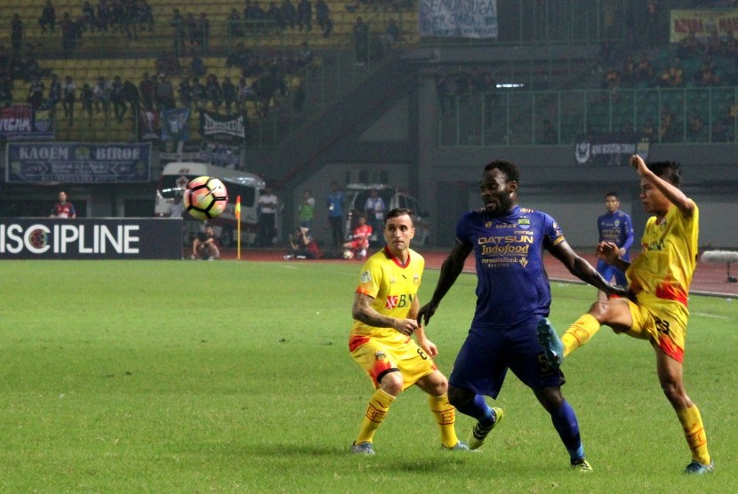 Pesepak bola Bhayangkara FC, Wahyu Sube Seto (kanan) berebut bola dengan pesepak bola Persib Bandung, Michael Essien (tengah) pada pertandingan Liga 1 di Stadion Patriot Candrabhaga, Bekasi, Jawa Barat, Ahad (4/6) malam. Bhayangkara FC menang dengan skor 2-0.