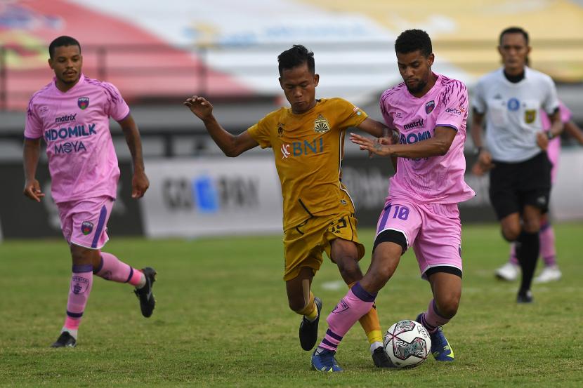 Pesepak bola Bhayangkara FC Wahyu Subo Seto (tengah) berebut bola dengan pemain Persita Tangerang Taylon Marcolino (kanan) dalam pertandingan sepak bola Liga 1 di Stadion I Wayan Dipta, Gianyar, Bali, Selasa (1/3/2022). Pertandingan berakhir imbang dengan skor 2-2. 