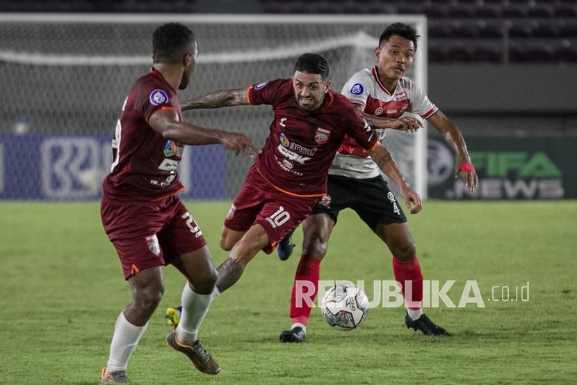 Pesepak bola Borneo FC Jonathan Ezequiel Bustos (tengah) berusaha melewati pesepak bola Madura United Asep Berlian (kanan) pada pertandingan Liga I di Stadion Manahan, Solo, Jawa Tengah, Selasa (14/12/2021). 