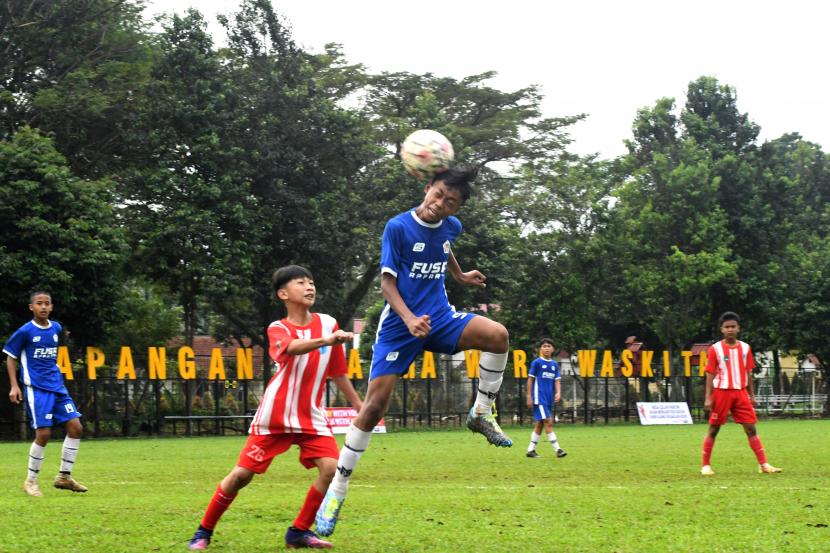 Pesepak bola dari tim Mutiara 97 menyundul bola dibayangi pesepak bola dari tim Bogor City dalam pertandingan King League One di Lapangan Graha Waskita, Cilendek, Kota Bogor, Jawa Barat, Ahad (17/7/2022). Kompetisi sepakbola usia muda yang diselenggarakan Askot PSSI Kota Bogor mulai U-14, U-15 dan U-16 yang diikuti 21 tim dari wilayah Jabodetabek dan Karawang tersebut sebagai ajang pembinaan dan pencarian pemain muda berbakat untuk tingkat nasional. 