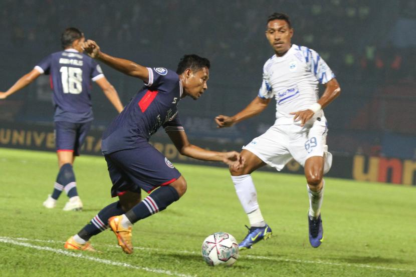 Pesepak bola Evan Dimas Darmono (kiri) berusaha melewati hadangan pesepak bola PSIS Semarang, Delfin Rumbino (kanan) dalam pertandingan Kompetisi Liga 1 di Stadion Kanjuruhan, Malang, Jawa Timur, Sabtu (30/7/2022). 