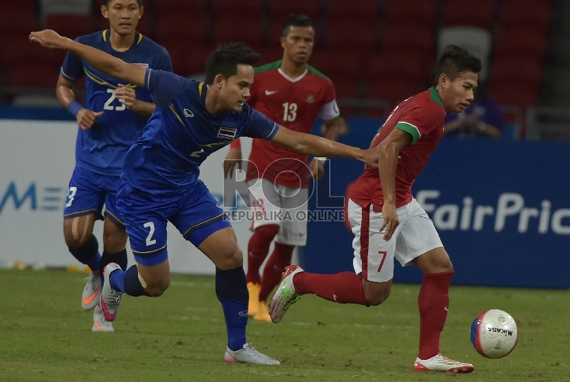 Pesepak bola Indonesia Ahmad Nufiandani (kanan) berebut bola dengan pesepak bola Thailand Peerapat Notechayia dalam pertandingan Semifinal Sepak Bola Sea Games ke-28, Sabtu (13/6).(ANTARA FOTO/Nyoman Budhiana)