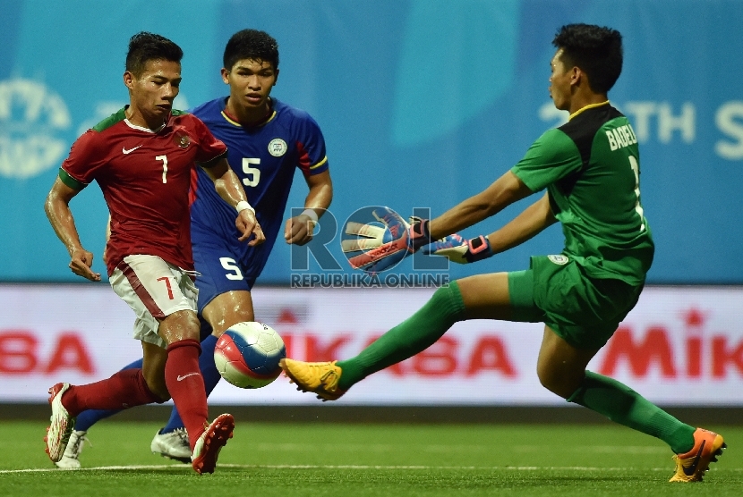 Pesepak bola Indonesia Ahmad Nurfiandani (kiri) mencoba melewati kiper Filipina dalam pertandingan putaran I Sepak Bola SEA Games ke-28, di Stadion Jalan Besar, Singapura, Selasa (9/6).(Antara/Wahyu Putro)