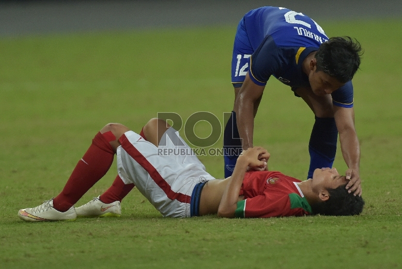 Pesepak bola Indonesia Evan Dimas Darmono mendapat simpati dari pesepakbola Thailand Nurul Sriyankem seusai pertandingan Semifinal Sepak Bola Sea Games ke-28, Sabtu (13/6).(ANTARA FOTO/Nyoman Budhiana)