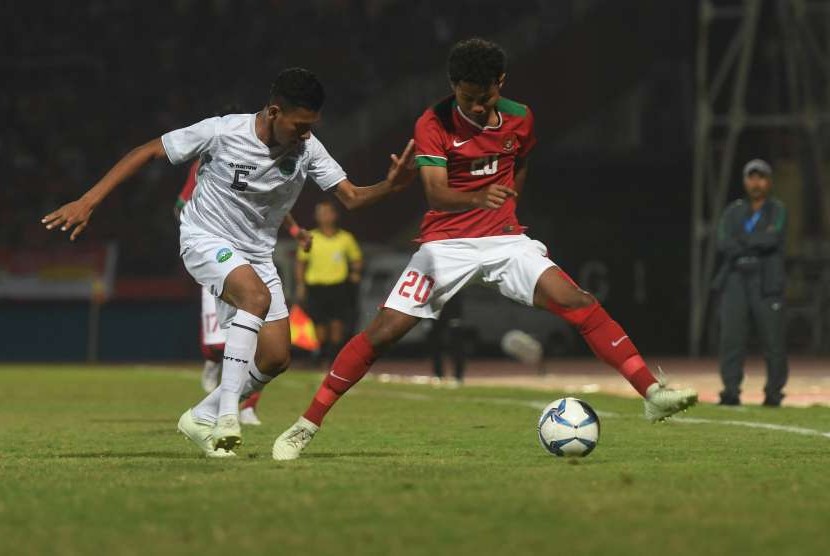 Pesepak bola Indonesia U-16 Amirudin Bagus Kahfi (kanan) menggiring bola dikawal pesepak bola Timor Leste U-16 Juvito Moniz (kiri) dalam laga penyisihan grup A Piala AFF U-16 di Gelora Delta Sidoarjo, Sidoarjo, Jawa Timur, Sabtu (4/8).