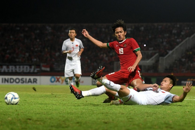 Pesepak bola Indonesia U-19 Hanis Saghara Putra (kiri) berebut bola dengan pesepak bola Vietnam U-19 dalam laga penyisihan grup A Piala AFF U19 Dang Van Toi (kanan) di Gelora Delta Sidoarjo, Sidoarjo, Jawa Timur, Sabtu (7/7). 