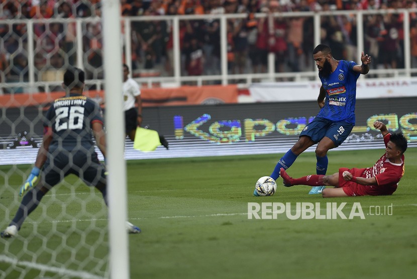 Pesepak bola klub Arema Malang Sylvano Comvalius (tengah) menendang bola dengan dikawal pesepak bola Persija Jakarta Sandi Sute (kanan) dalam pertandingan lanjutan Liga 1 2019 di Stadion Utama Gelora Bung Karno (SUGBK), Jakarta, Sabtu (3/8/2019). 