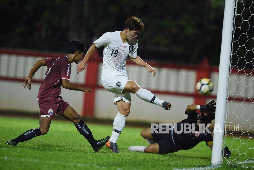 Pesepak bola Korsel U-23 Keunho Lee (tengah) menendang bola ke gawang Persija Jakarta yang dikawal penjaga gawang Andritany (kanan) dalam laga uji coba di Stadion PTIK, Jakarta, Kamis (21/6). 