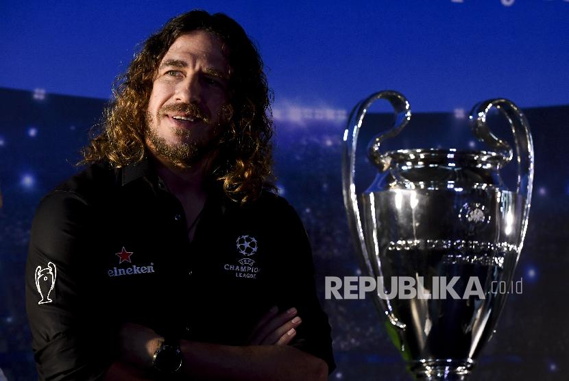 Pesepak bola legenda FC Barcelona Carles Puyol berpose di dekat trofi Liga Champion saat mengikuti UEFA Champions League Thropy Tour di Jakarta, Senin (11/3).