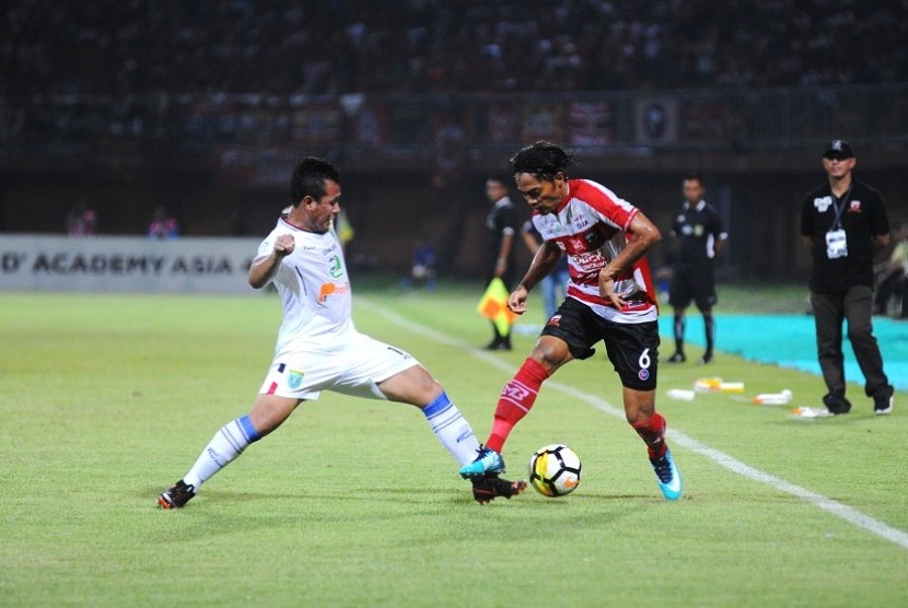 Pesepak bola Madura United (MU) Andik Rendika Rama (kanan) berusaha melewati pesepak bola Persela Lamongan Guntur A Riyadi (kiri) dalam kompetisi Liga 1 di Stadion Gelora Ratu Pamelingan (SGRP) Pamekasan, Jawa Timur, Sabtu (8/12/2018). 