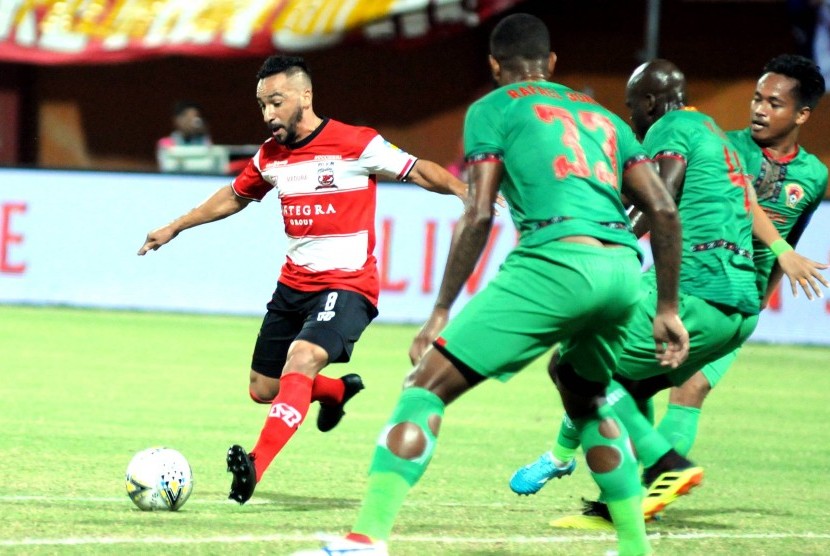 Pesepak bola Madura United (MU) Diego Assis (kanan) berusaha melewati pesepak bola Kalteng Rafael De Jesus (tengah) dalam laga Shopee Liga 1 di Stadion Gelora Madura Ratu Pamelingan (SGMRP) Pamekasan, Jawa Timur, Ahad (1/9).