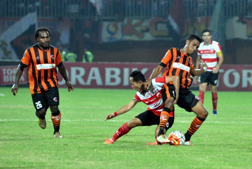 Pesepak bola Madura United (MU) FC Slamet Nurcahyo (kedua kiri) berebut bola dengan pesepak bola Perseru Serui Bryan Nus Muabuay saat babak penyisihan Grup E turnamen Piala Presiden di Stadion Gelora Ratu Pamelingan (SGRP), Pamekasan, Jawa Timur, Selasa (1