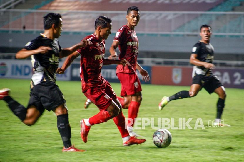 Pesepak bola Martapura Dewa United Suhandi (kiri) berebut bola dengan pesepak bola Persis Solo Abduh Lestaluhu (kedua kiri) dalam lanjutan Liga 2 babak semi final di Stadion Pakansari, Kabupaten Bogor, Jawa Barat, Senin (27/12/2021). 