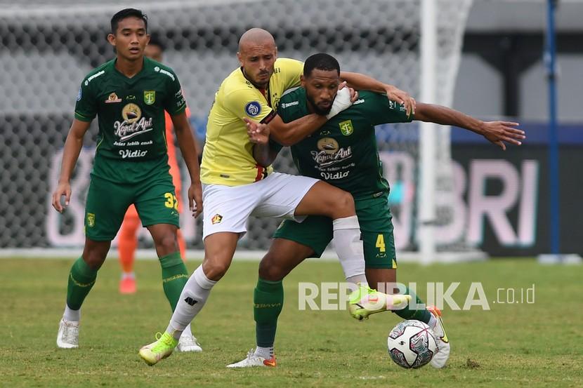 Pesepak bola Persebaya Alie Sesay (kanan) dihadang pemain Persik Kediri Ezzejari (kedua kanan) dalam pertandingan sepak bola Liga 1 di Stadion I Wayan Dipta, Gianyar, Bali, Kamis (10/3/2022). Persebaya berhasil menang dengan skor 1-0. 