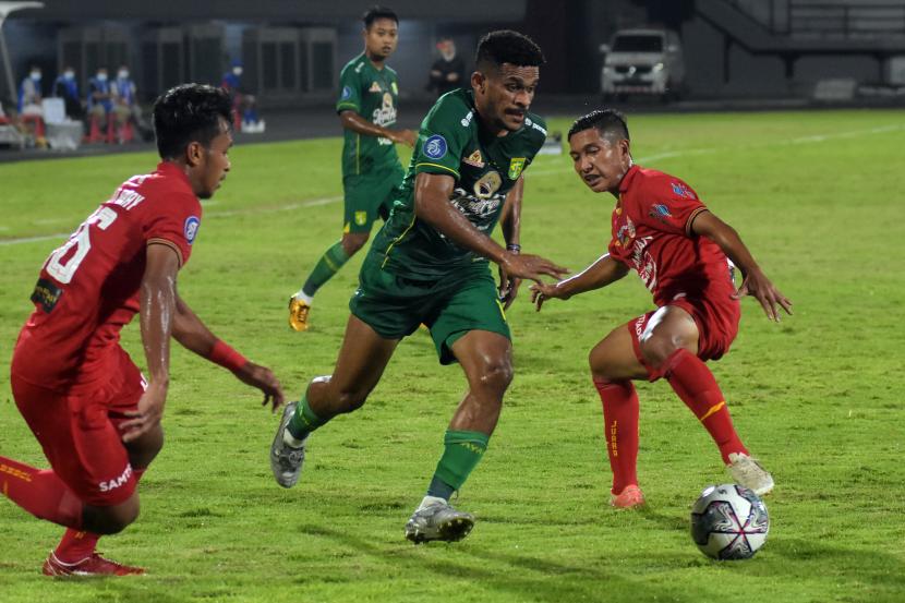 Pesepak bola Persebaya Surabaya Ricky Kambuaya (tengah) berusaha melewati hadangan pesepak bola Persija Jakarta Osvaldo Haay (kiri) dan Rangga Widiansyah (kanan) pada pertandingan Liga 1 di Stadion Kapten I Wayan Dipta, Gianyar, Bali, Senin (14/2/2022) malam. Pertandingan tersebut berakhir imbang dengan skor 3-3.