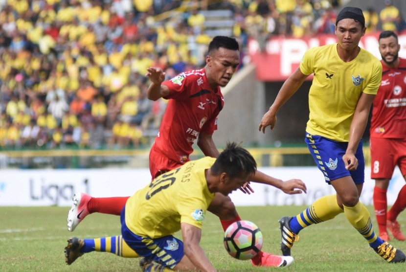 Pesepak bola Persegres Gresik United Jeki Arisandi (kiri) berebut bola dengan pesepak bola Semen Padang Adi Nugroho (kedua kiri) dalam pertandingan Gojek Traveloka Liga 1 di Stadion Petrokimia, Gresik, Jawa Timur, Jumat (21/4). 