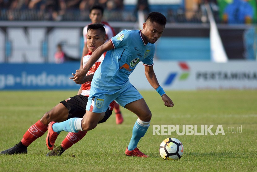 Pesepak bola Persela Lamongan Saddil Ramdani (kanan) melewati hadangan pesepak bola Madura United Asep Berlian (kiri) dalam lanjutan pertandingan Liga-1 di Stadion Surajaya Lamongan, Jawa Timur, Senin (23/7).