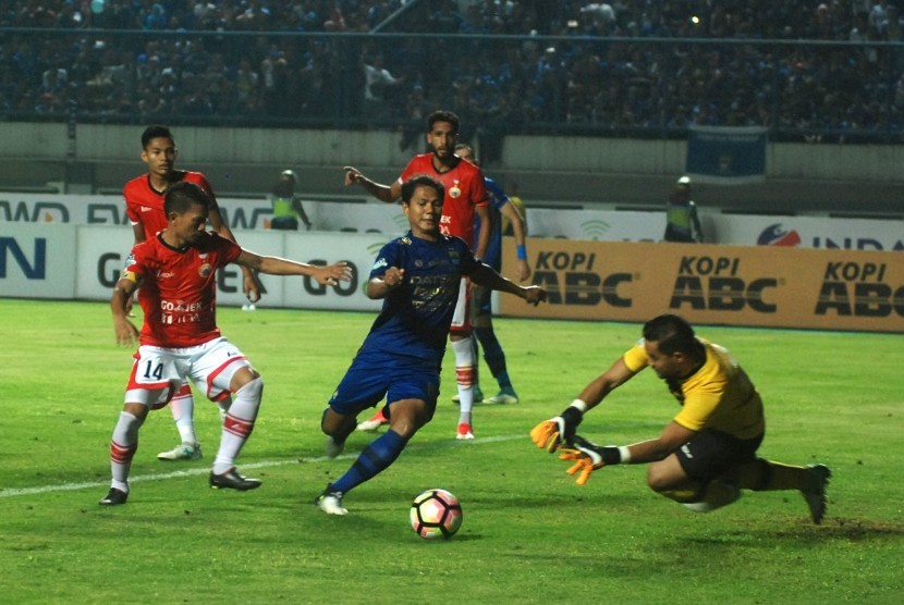 Pesepak bola Persib Bandung Achmad Jufriyanto (tengah) berusaha merebut bola dari penjaga gawang Persija Jakarta Andritany (kanan) pada laga lanjutan Liga 1 di Stadion Gelora Bandung Lautan Api (GBLA) Gedebage, Bandung, Jawa Barat, Sabtu (22/7). 