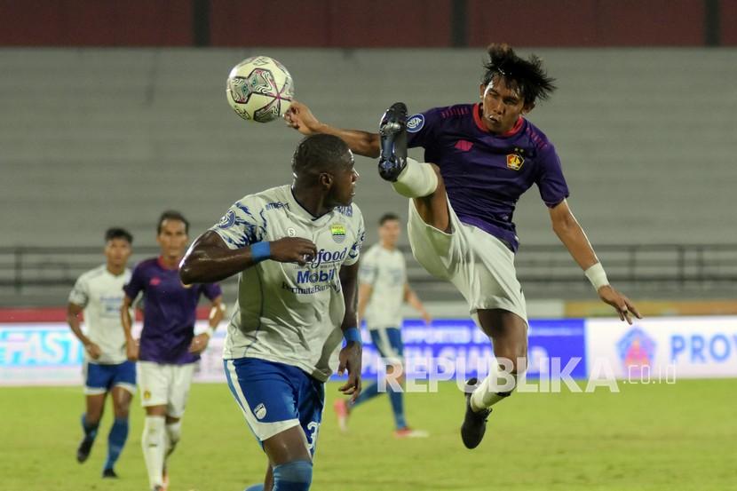 Pesepak bola Persib Bandung Bruno Cantanhede (kiri) berebut bola dengan pesepak bola Persik Kediri Yusuf (kanan) pada pertandingan Liga 1 di Stadion Kapten I Wayan Dipta, Gianyar, Bali, Jumat (25/3/2022). Pertandingan berakhir imbang dengan skor 0-0. 