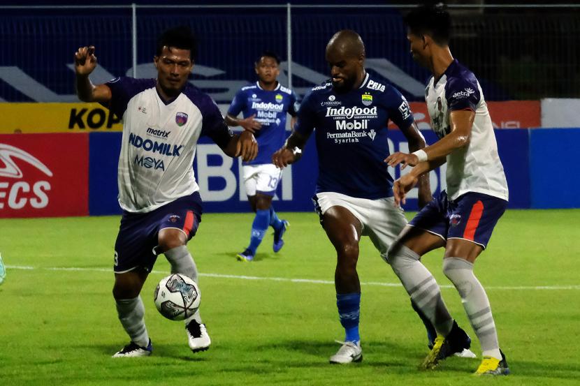 Pesepak bola Persib Bandung David Da Silva (tengah) berebut bola dengan pesepak bola Persita Agung Prasetyo (kiri) dan Syaeful Anwar (kanan) pada pertandingan Liga 1 di Stadion I Gusti Ngurah Rai, Denpasar, Bali, Jumat (7/1/2022). Persib memenangi pertandingan melawan Persita 1-0.