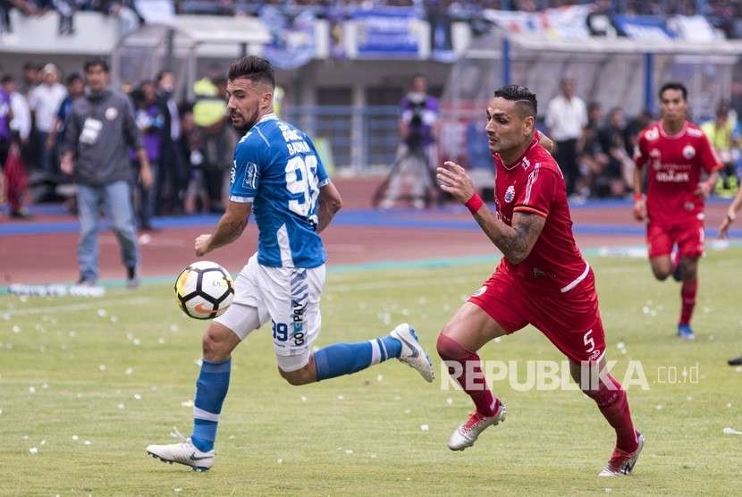 Pesepak bola Persib Bandung Jonatan Bauman (kiri) berebut bola dengan pesepak bola Persija Jakarta Jameirson Xavier (kanan) pada pertandingan lanjutan Go-Jek Liga 1 2018 di Stadion Gelora Bandung Lautan Api, Bandung, Jawa Barat, Ahad (23/9).