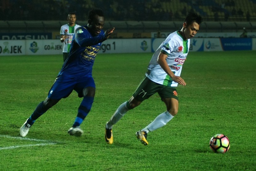 Pesepak bola Persib Bandung Michael Essien (kiri) berusaha mengejar bola dari pesepak bola PS TNI Yus Arfandi (kanan) pada laga lanjutan Liga 1 di Stadion Si Jalak Harupat Soreang, Kabupaten Bandung, Jawa Barat, Sabtu (5/8). Tim tuan rumah Persib Bandung mengalahkan tim tamu PS TNI dengan skor akhir 3-1.