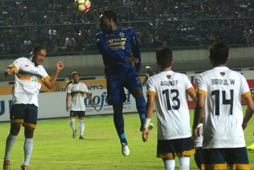 Pesepak bola Persib Bandung Michael Essien (tengah) menyundul bola dengan kawalan sejumlah pesepak bola Persela Lamongan pada laga lanjutan Liga 1 Indonesia di Stadion Gelora Bandung Lautan Api (GBLA) Gedebage, Bandung, Jawa Barat, Rabu (12/7). Pertandingan tersebut berakhir imbang 1-1.