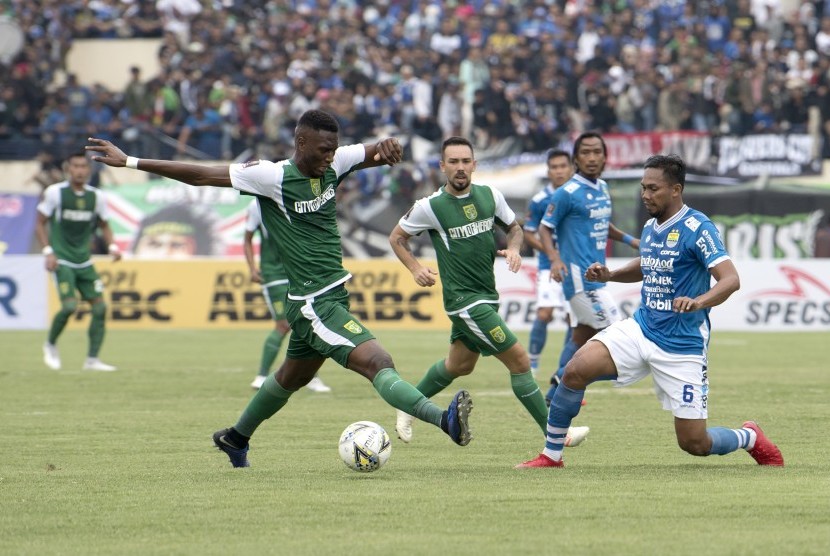 Pesepak bola Persib Bandung Saepuloh Maulana (kanan) berebut bola dengan pesepak bola Persebaya Surabaya Amido Balde (kiri) saat pertandingan Grup A Piala Presiden di Stadion Si Jalak Harupat, Kabupaten Bandung, Jawa Barat, Kamis (7/3/2019).