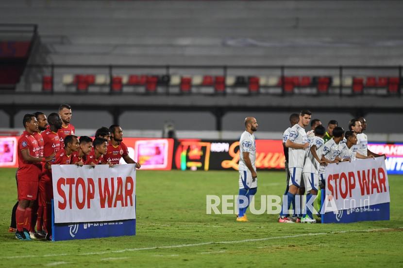 Pesepak bola Persija Jakarta dan Persib Bandung membentangkan spanduk bertuliskan Stop War menjelang pertandingan sepak bola Liga 1 di Stadion I Wayan Dipta, Gianyar, Bali, beberapa waktu lalu.