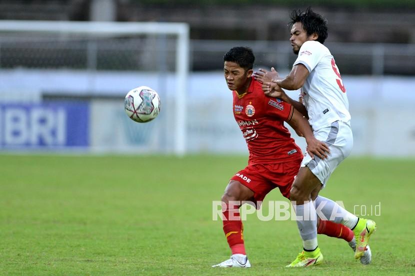 Pesepak bola Persija Jakarta Ilham Rio Fahmi (kiri) berebut bola dengan pesepak bola PSM Makassar Saldi (kanan) saat pertandingan Liga 1 di Stadion I Gusti Ngurah Rai, Denpasar, Bali, Senin (21/3/2022). Persija Jakarta mengalahkan PSM Makassar dengan skor 3-1.