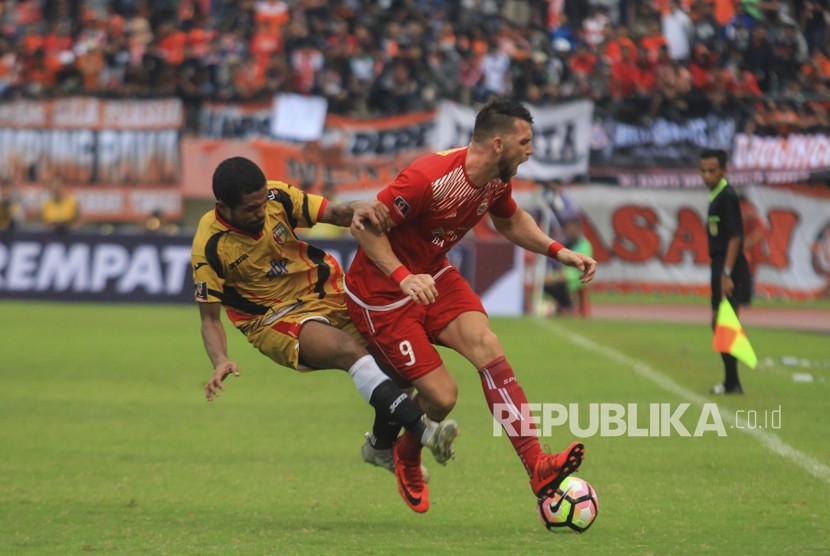 Pesepak bola Persija Jakarta, Marko Simic (kanan) dihadang pesepak bola Mitra Kukar FC, Abdul Gamal (kiri) pada pertandingan delapan besar Piala Presiden di Stadion Manahan Solo, Jawa Tengah, Ahad (4/2).