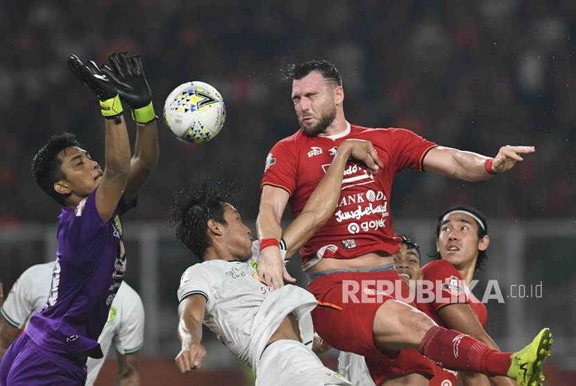 Pesepak bola Persija Jakarta Marko Simic (kedua kanan) berusaha menyundul bola dengan dihadang penjaga gawang Persebaya Surabaya Miswar Saputra (kiri) dalam lanjutan Liga-1 Indonesia di Stadion Utama Gelora Bung Karno (GBK), Jakarta, Selasa (17/12/2019).