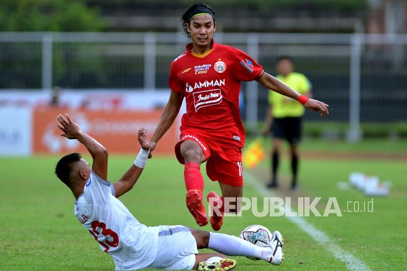 Pesepak bola Persija Jakarta Novri Setiawan (kanan) dihadang pesepak bola PSM Makassar Dallen Doke (kiri) saat pertandingan Liga 1 di Stadion I Gusti Ngurah Rai, Denpasar, Bali, Senin (21/3/2022). Persija Jakarta mengalahkan PSM Makassar dengan skor 3-1. 