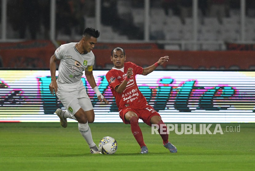 Pesepak bola Persija Jakarta Riko Simanjuntak (kanan) berusaha melewati adangan pesepak bola Persebaya Surabaya Rachmat Irianto (kiri) dalam lanjutan Liga-1 Indonesia di Stadion Utama Gelora Bung Karno (GBK), Jakarta, akhir tahun lalu. 