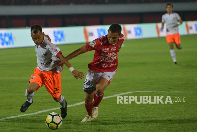 Pesepak bola Persija Riko Simanjuntak (kiri) berebut bola dengan pemain Bali United Ricky Fajrin pada pertandingan Sepak Bola Liga 1 di Stadion I Wayan Dipta, Gianyar, Bali, Ahad (02/12/2018). 