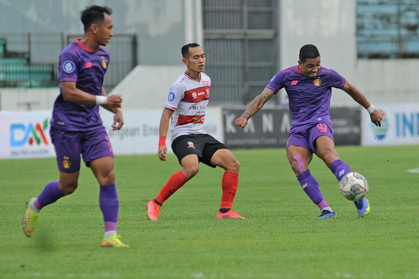 Pesepak bola Persik Kediri Machado De Olievera (kanan) menggiring bola dengan dihadang pemain Madura United David Laly (tengah) saat pertandingan Liga 1 di stadion Moh Subroto Magelang, Jawa Tengah, Rabu (24/11/2021). Madura United mengalahkan Persik Kediri dengan skor 2-0.