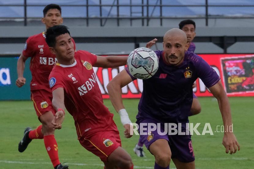 Pesepak bola Persik Kediri Youssef Ezzejjari (kanan) berebut bola dengan pesepak bola Bhayangkara FC Putu Gede (kiri) pada pertandingan Liga 1 di Stadion Kapten I Wayan Dipta, Gianyar, Bali, Jumat (28/1/2022). Persik Kediri menang atas Bhayangkara FC dengan skor 1-0. 