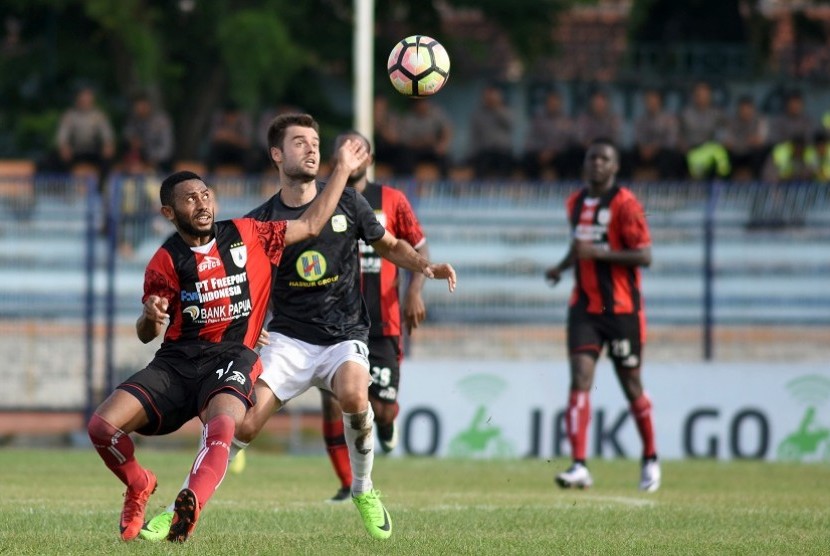 Pesepak bola Persipura Jayapura Marcel A Kararbo (kiri) berebut bola dengan pesepak bola Barito Putra Douglas P (kanan)