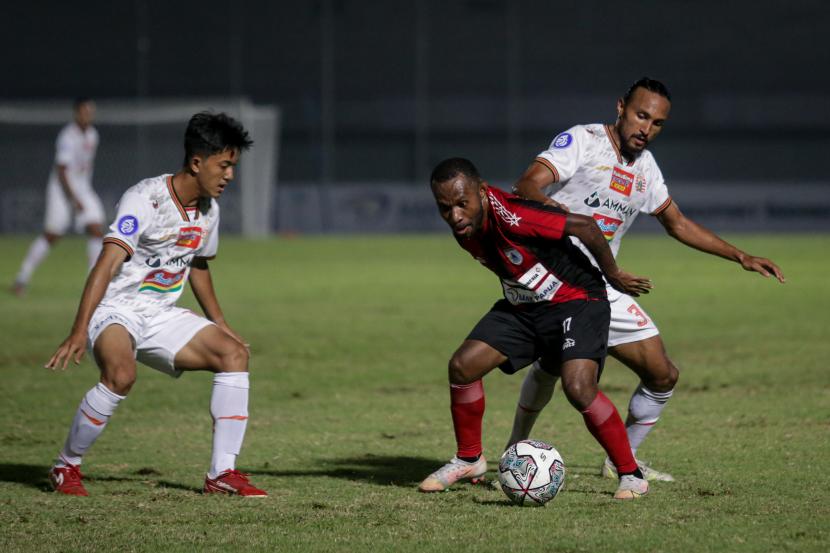 Pesepak bola Persipura Jayapura Yohanes Pahabol (tengah) berebut bola dengan pesepak bola Persija Jakarta Rohit Chand (kanan) pada laga lanjutan Liga 1 2021-2022 di Stadion Indomilk Arena, Tangerang, Banten, Ahad (19/9/2021). Pertandingan tersebut berakhir imbang dengan skor 0-0.