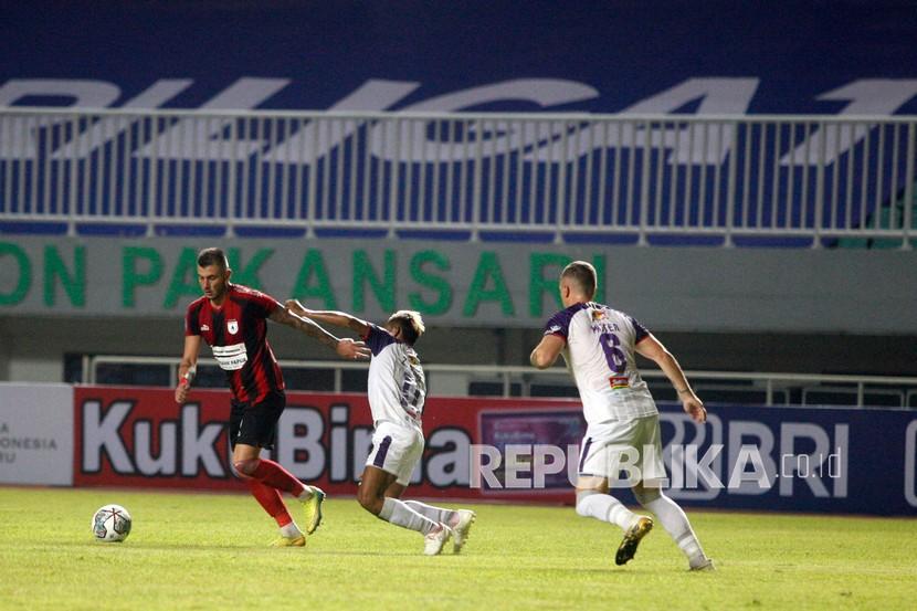 Pesepak bola Persipura Yevhen Bokhashvili (kiri) menguasai bola dibayangi pesepak bola Persita Muhammad Toha (tengah) pada laga Liga 1 di Stadion Pakansari, Kabupaten Bogor, Jawa Barat, Sabtu (28/8/2021). 