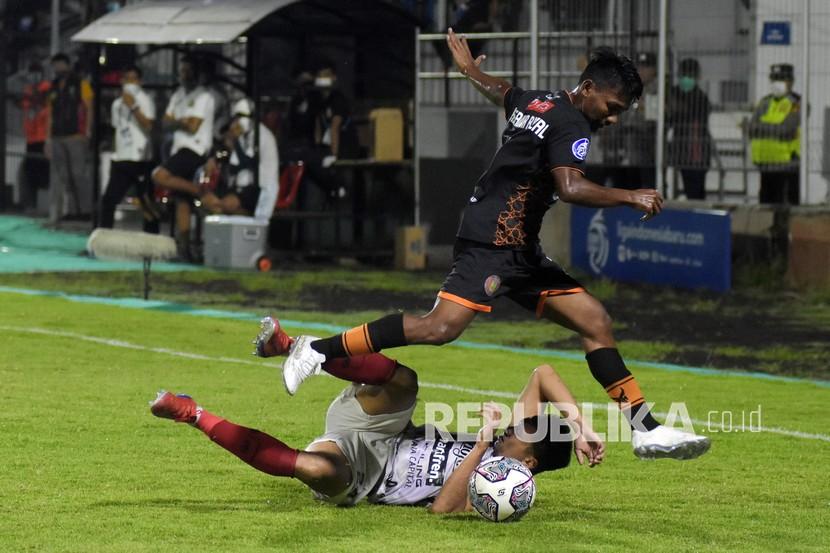 Pesepak bola Persiraja Banda Aceh Assanur Rijal (atas) melompat saat berebut bola dengan Bali United Ricky Fajrin (bawah) pada pertandingan Liga 1 di Stadion Kompyang Sujana, Denpasar, Bali, Jumat (11/3/2022) malam. Bali United berhasil kalahkan Persiraja Banda Aceh dengan skor 1-0. 