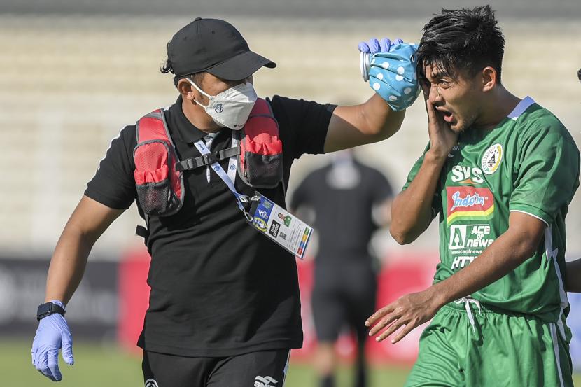 Pesepak bola PS Sleman Aryad Yusgiantoro (kanan) mendapat perawatan saat bertanding melawan Madura United dalam lanjutan Liga 1 2021-2022 di Stadion Madya Gelora Bung Karno, Jakarta, Sabtu (25/9/2021).